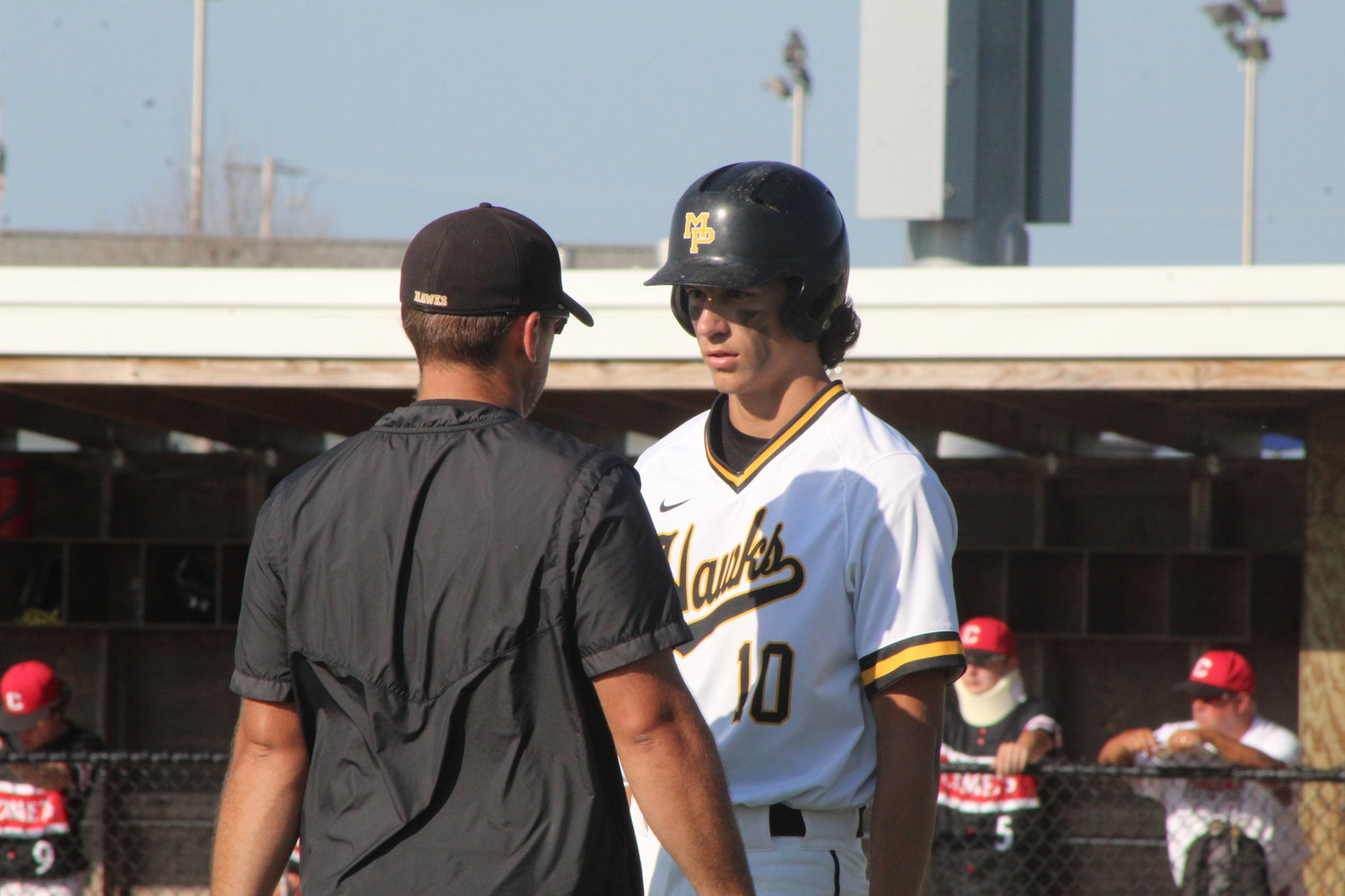 Mid-Prairie head coach Kyle Mullet instructs Collin Miller prior to an at-bat in a recent game.